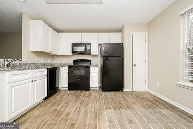 a kitchen with a refrigerator a stove top oven a sink and dishwasher
