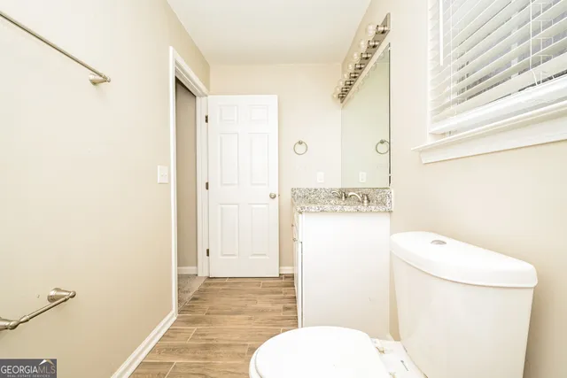 a bathroom with a granite countertop toilet sink and shower