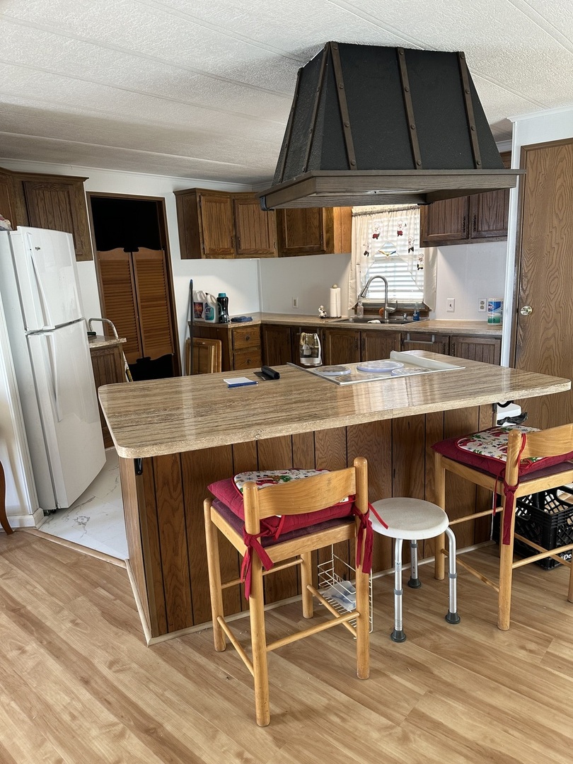 6801 South La Grange Road, Unit 155 Hodgkins, IL 60525 - Photo 4 of 8 a kitchen with stainless steel appliances granite countertop a table chairs sink and cabinets