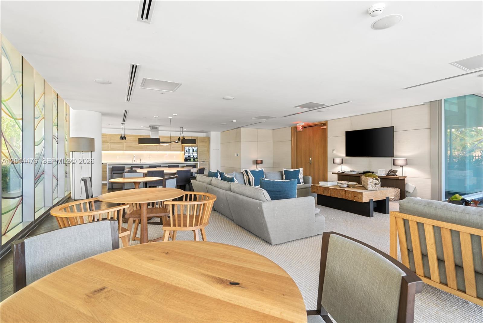 360 Ocean Drive, Unit 1106S Key Biscayne, FL 33149 - Photo 33 of 67 Amenity Lounge / Dining Area – This amenity space offers multiple seating areas, dining tables, and an open kitchen for flexible entertaining. Floor-to-ceiling glass and warm wood details add light and texture throughout the room.