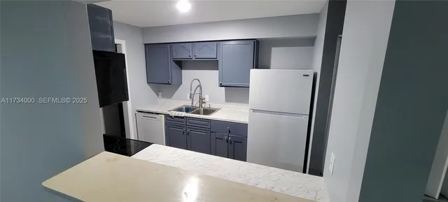 a kitchen with a refrigerator sink and cabinets