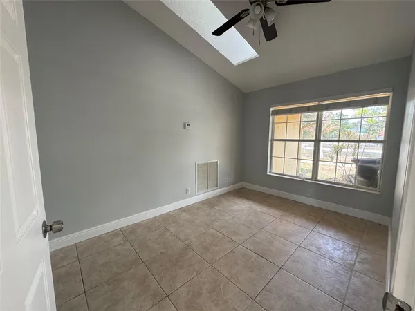 an empty room with windows and fan