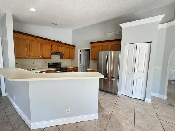a kitchen with refrigerator and cabinets