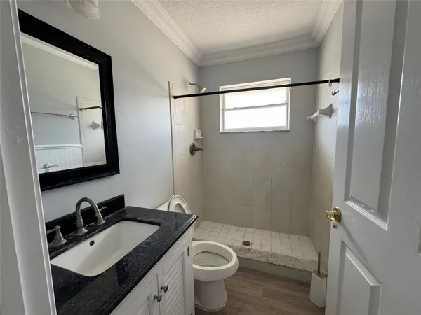 a bathroom with a granite countertop sink toilet and shower