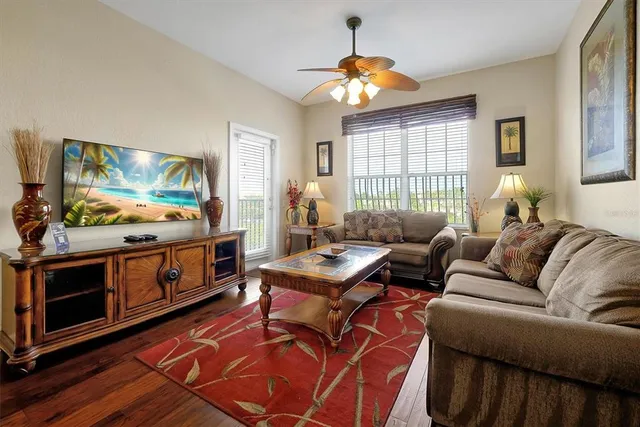 a living room with furniture a flat screen tv and a window