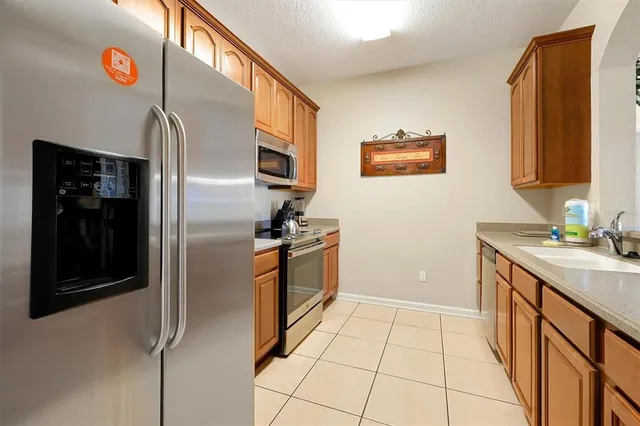 a kitchen with granite countertop a refrigerator and a stove top oven