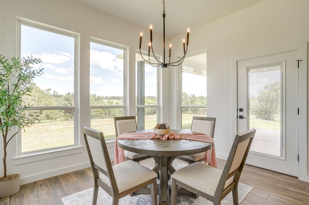 9012 Valley Oak Court Springtown, TX 76082 - Photo 18 of 40 a view of a dining room with furniture window and wooden floor