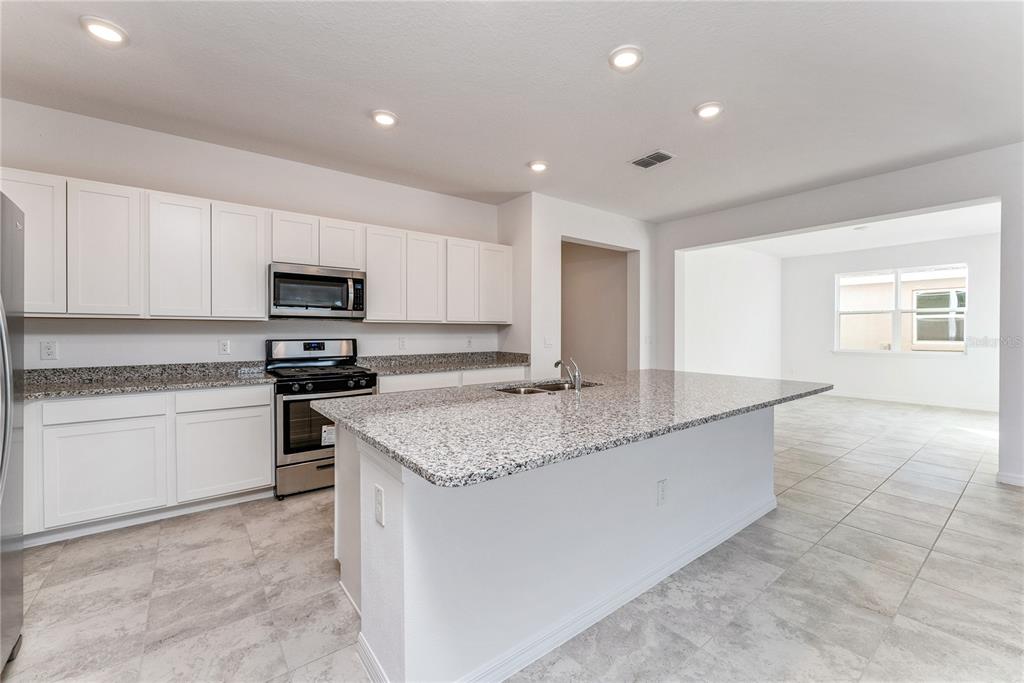 7405 Southwest 61st Street Ocala, FL 34474 - Photo 12 of 46 a kitchen with stainless steel appliances granite countertop a sink stove and cabinets
