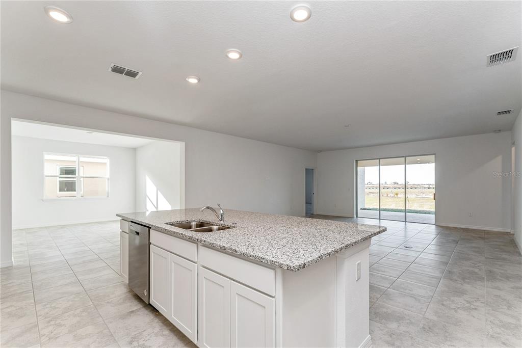 7405 Southwest 61st Street Ocala, FL 34474 - Photo 13 of 46 a kitchen with granite countertop sink stove and cabinets
