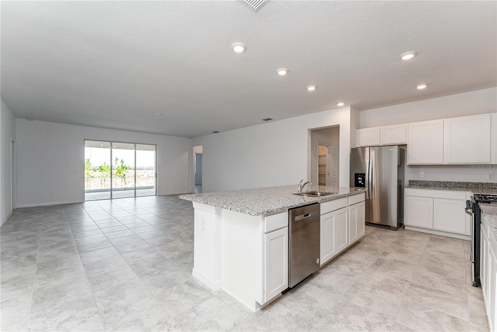 7405 Southwest 61st Street Ocala, FL 34474 - Photo 15 of 46 a kitchen with stainless steel appliances granite countertop a refrigerator and a stove top oven
