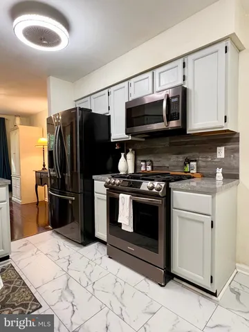 a kitchen with stainless steel appliances granite countertop a stove refrigerator and microwave