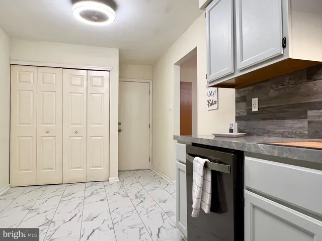 a kitchen with granite countertop a sink stainless steel appliances and cabinets