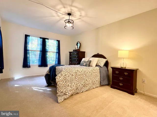 a spacious bedroom with a bed and a dresser