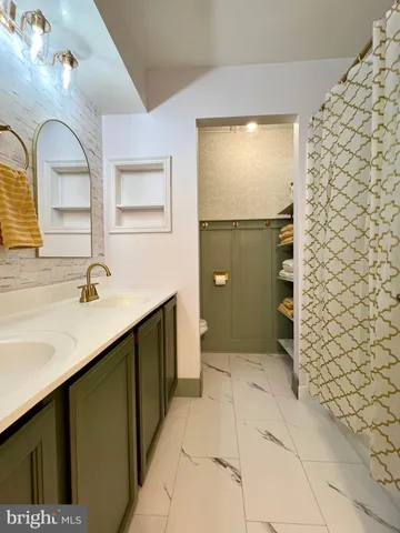 a bathroom with a sink a toilet and mirror