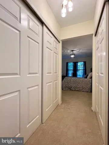 a view of a hallway with closet and chandelier
