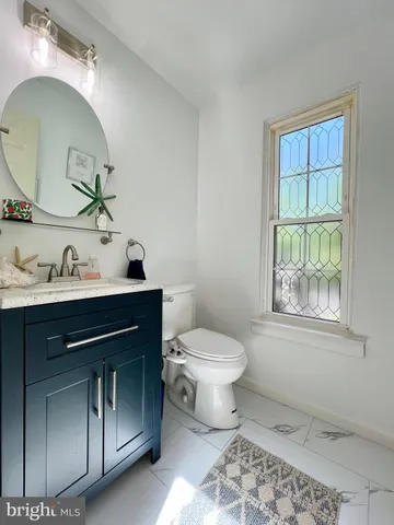 a bathroom with a sink a toilet and a mirror
