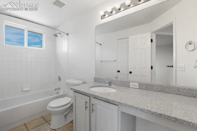 a bathroom with a granite countertop sink a toilet and shower