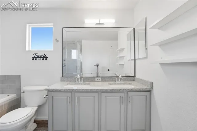 a bathroom with a granite countertop sink a toilet and a mirror