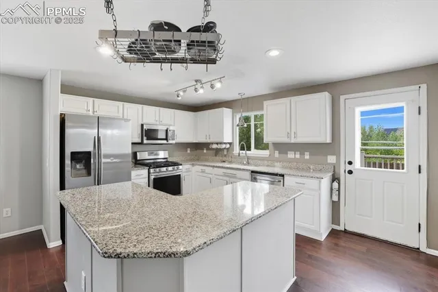a kitchen with stainless steel appliances granite countertop a sink a stove and a refrigerator