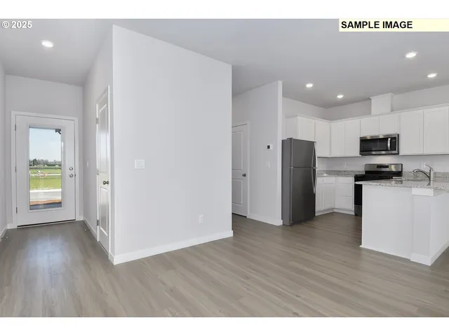 a view of kitchen with stainless steel appliances refrigerator stove microwave and cabinets
