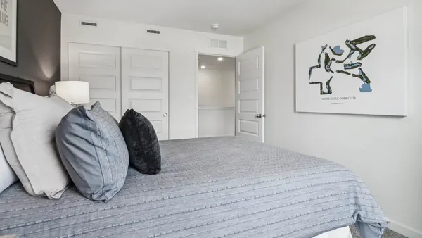 a bedroom with a bed and a painting on the wall