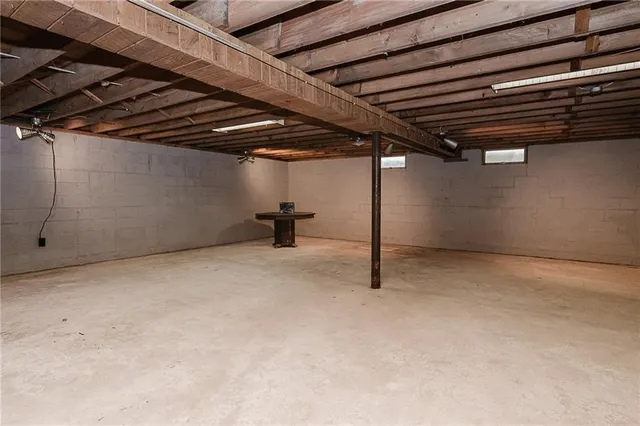 a view of an empty room with furniture and windows