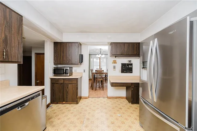 a kitchen with kitchen island a refrigerator and a stove top oven