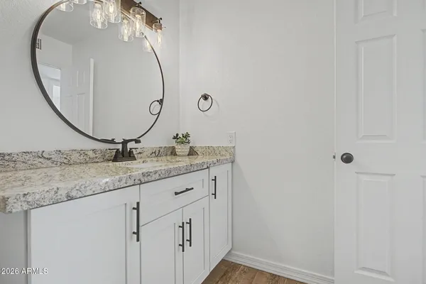 a bathroom with a granite countertop sink and a mirror
