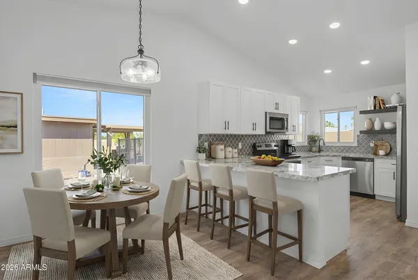 a view of kitchen with refrigerator dining table and chairs