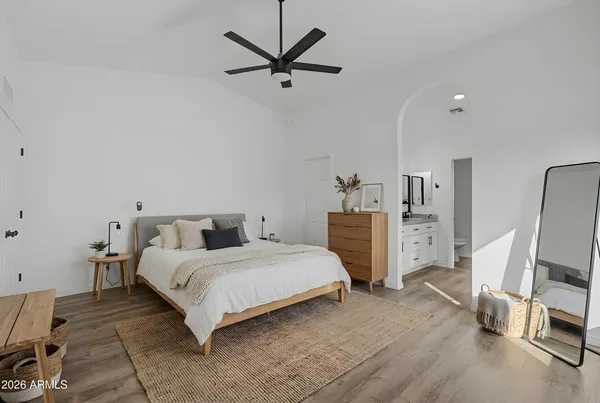 a bedroom with a bed a couch and a chandelier