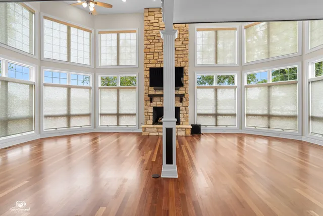 a view of empty room with wooden floor and windows