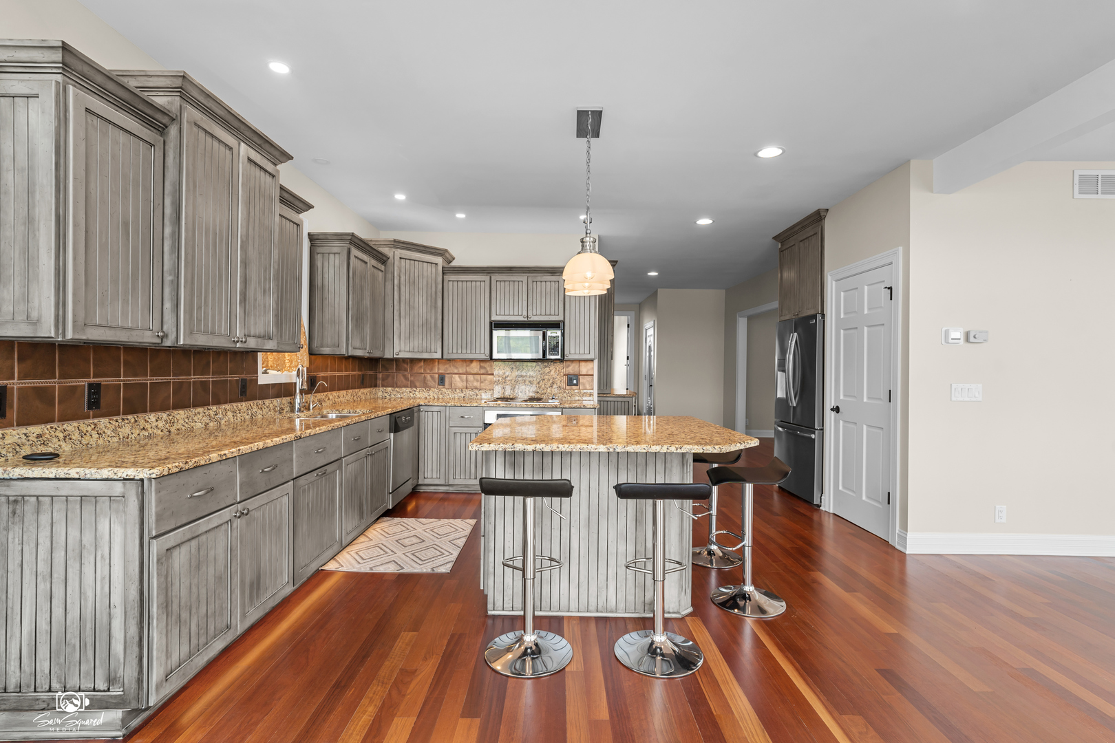 8043 Tamarack Lane Morris, IL 60450 - Photo 14 of 55 a kitchen with stainless steel appliances kitchen island granite countertop wooden floors and view living room