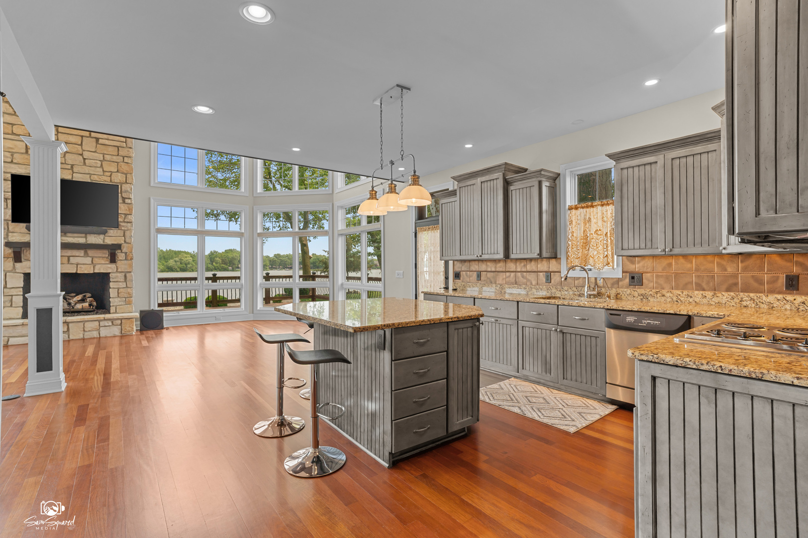 8043 Tamarack Lane Morris, IL 60450 - Photo 16 of 55 a kitchen with kitchen island granite countertop wooden floors and wide window