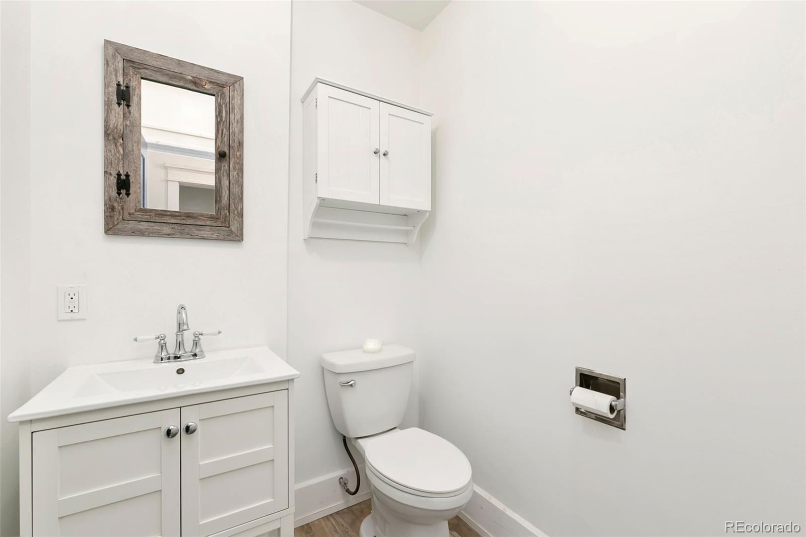 924 Teal Drive Fort Collins, CO 80521 - Photo 22 of 32 a bathroom with a toilet a sink a mirror and vanity
