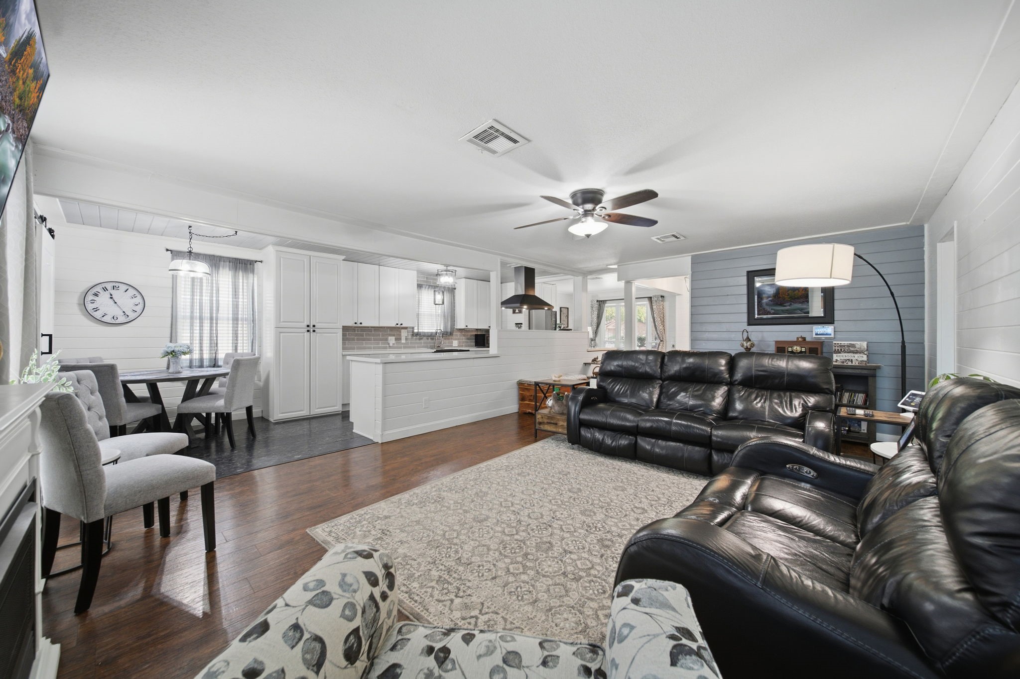 19519 Ricelake Lane Houston, TX 77084 - Photo 16 of 47 Spacious open-concept living area with modern finishes features a cozy seating arrangement, a stylish kitchen with a breakfast bar, and an inviting dining space perfect for entertaining.