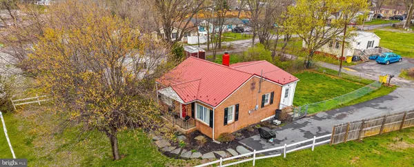 an aerial view of a house with swimming pool and large trees