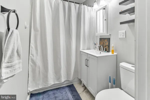 a bathroom with a sink a toilet and shower curtain