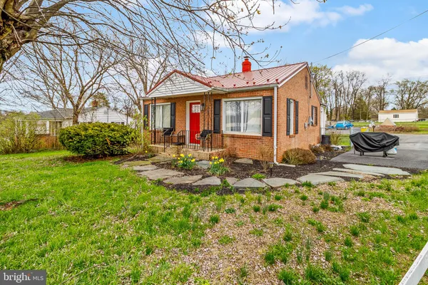 a front view of a house with garden and sitting area