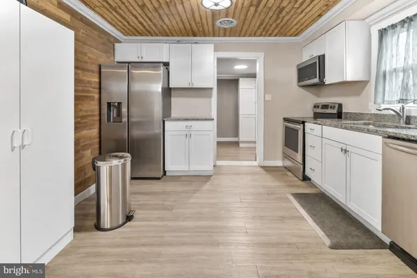 a kitchen with stainless steel appliances granite countertop a refrigerator and a sink