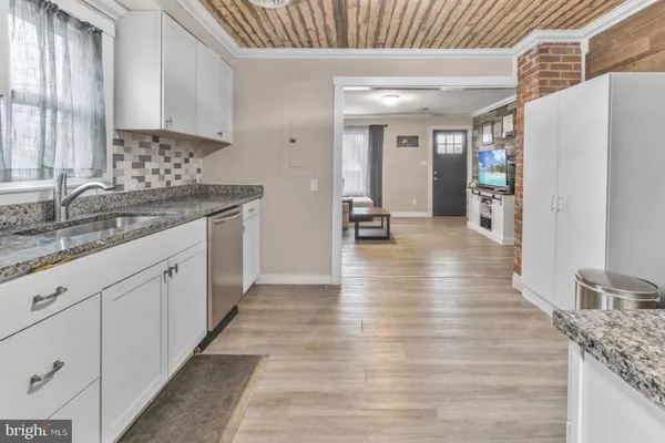 a kitchen with granite countertop a sink and cabinets