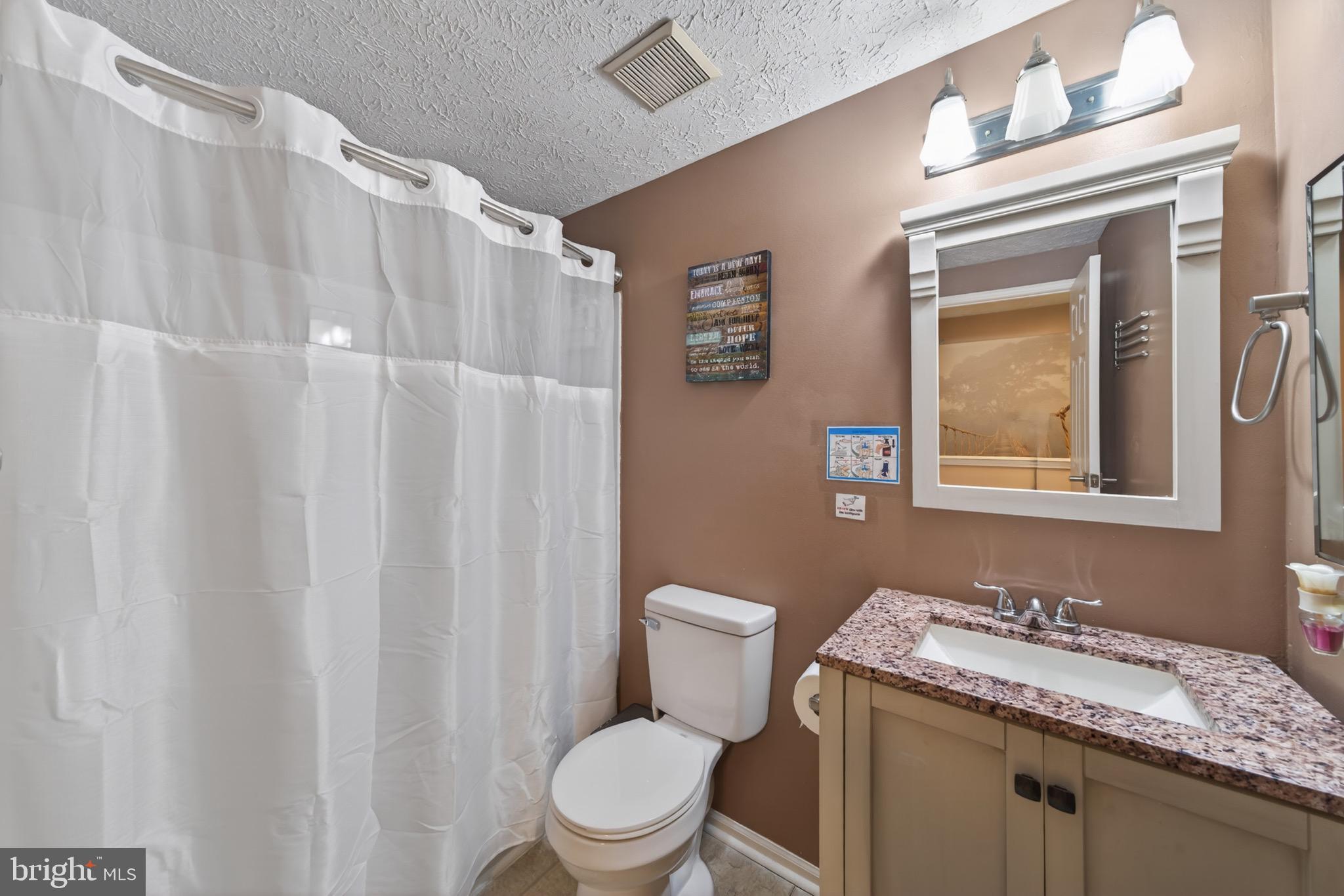 15095 Mill Spring Drive Dumfries, VA 22025 - Photo 15 of 36 a bathroom with a granite countertop toilet sink and mirror