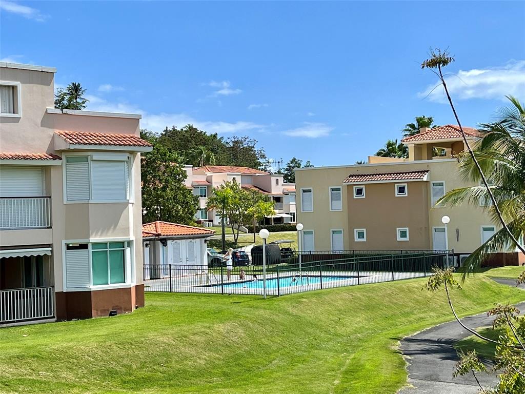 180 Harbour Lakes, Unit 25A Humacao, PR 00791 - Photo 1 of 1 a view of a house with a big yard potted plants and a large tree
