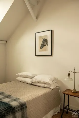 a bedroom with a bed and a painting on the wall