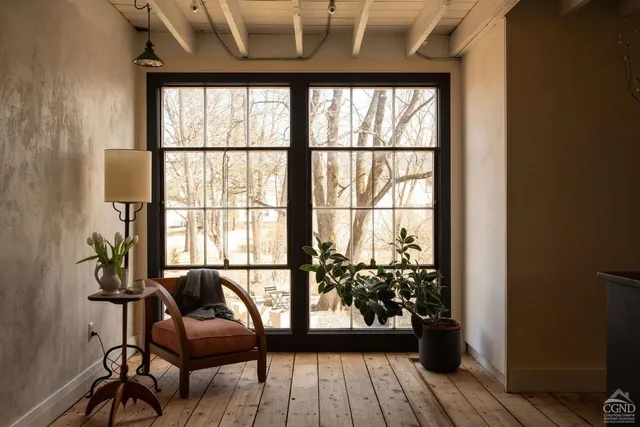 a view of a hallway with wooden floor and a living room