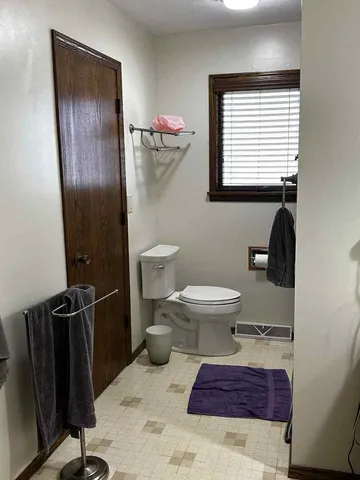 a bathroom with a toilet a sink and mirror