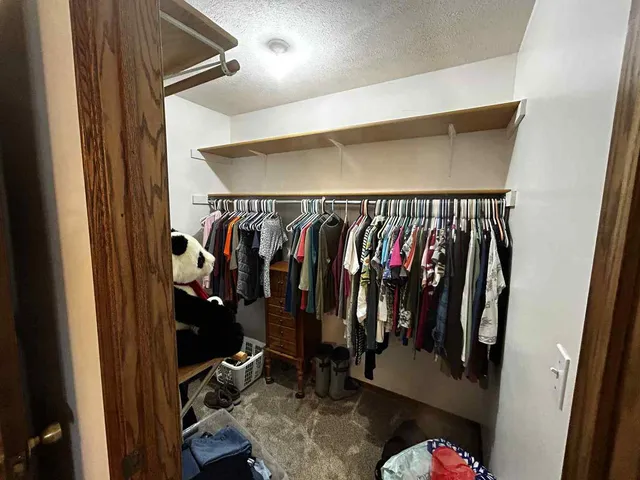a view of walk in closet with clothes and shoes