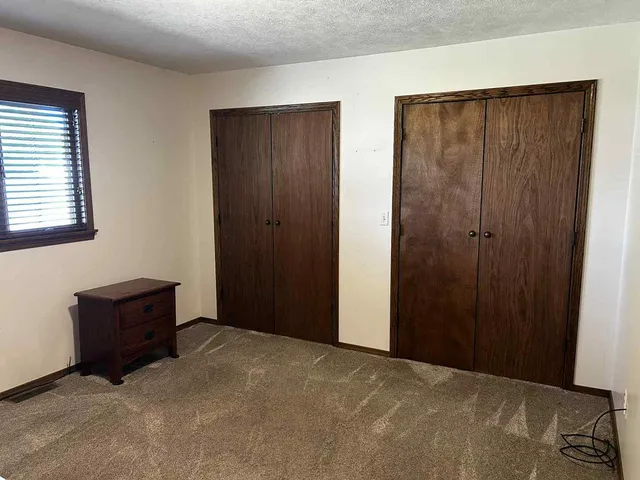 a spacious bedroom with a large bed and a chandelier