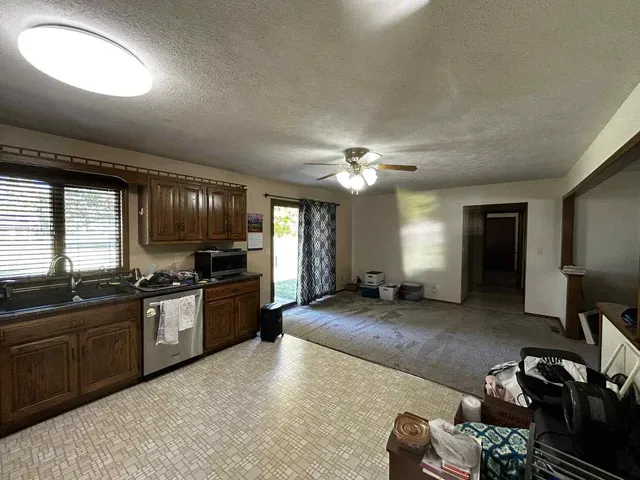 a large open kitchen with a large window and stainless steel appliances