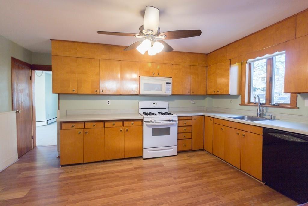 46 Eliot Crescent Brookline, MA 02467 - Photo 2 of 15 a kitchen with stainless steel appliances granite countertop a sink a stove a refrigerator cabinets and wooden floor