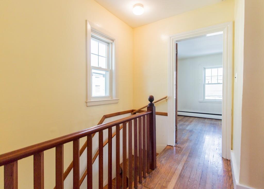 46 Eliot Crescent Brookline, MA 02467 - Photo 7 of 15 a view of a hallway with wooden floor and a window